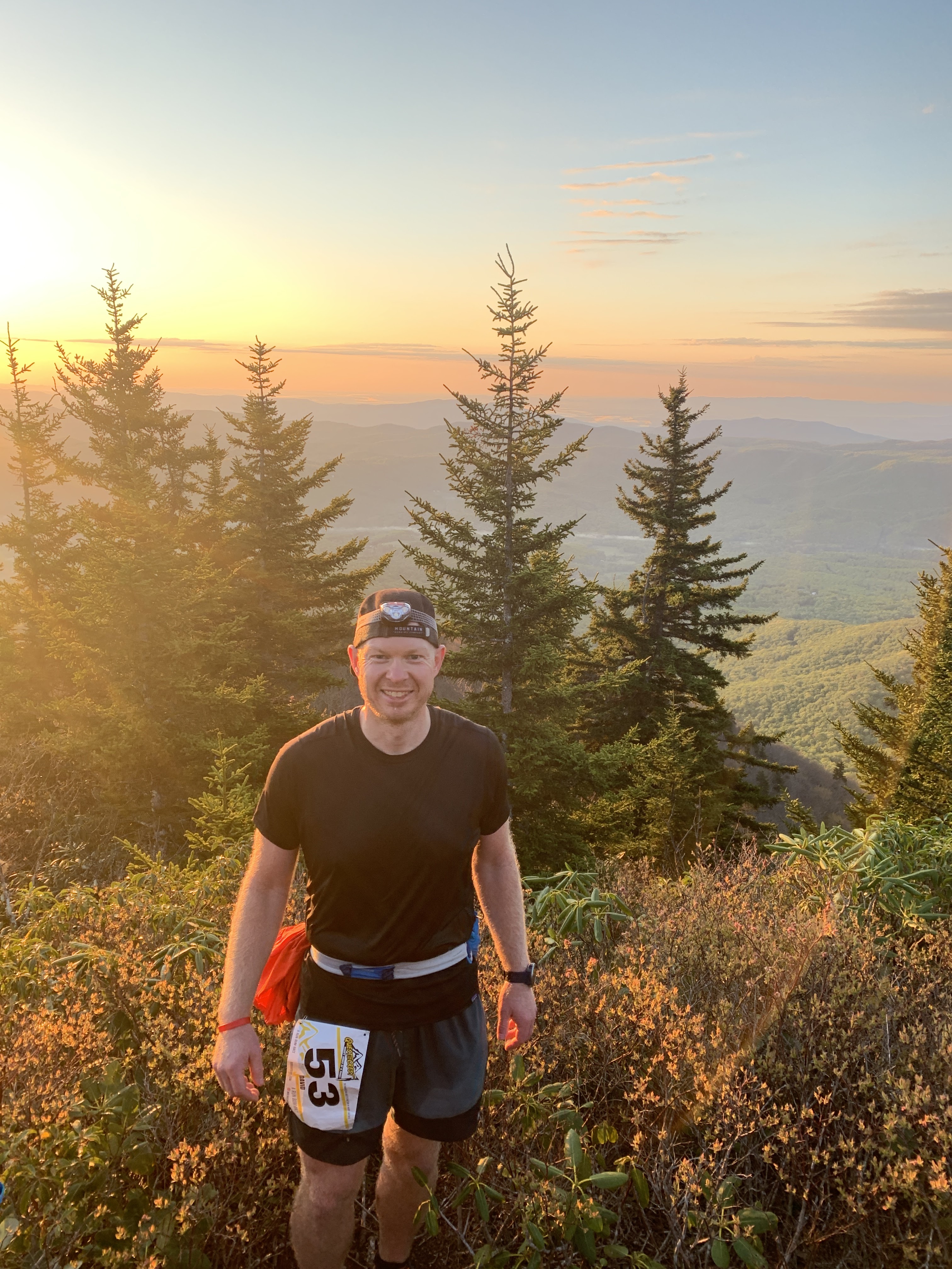 David at a mountain summit during golden hour